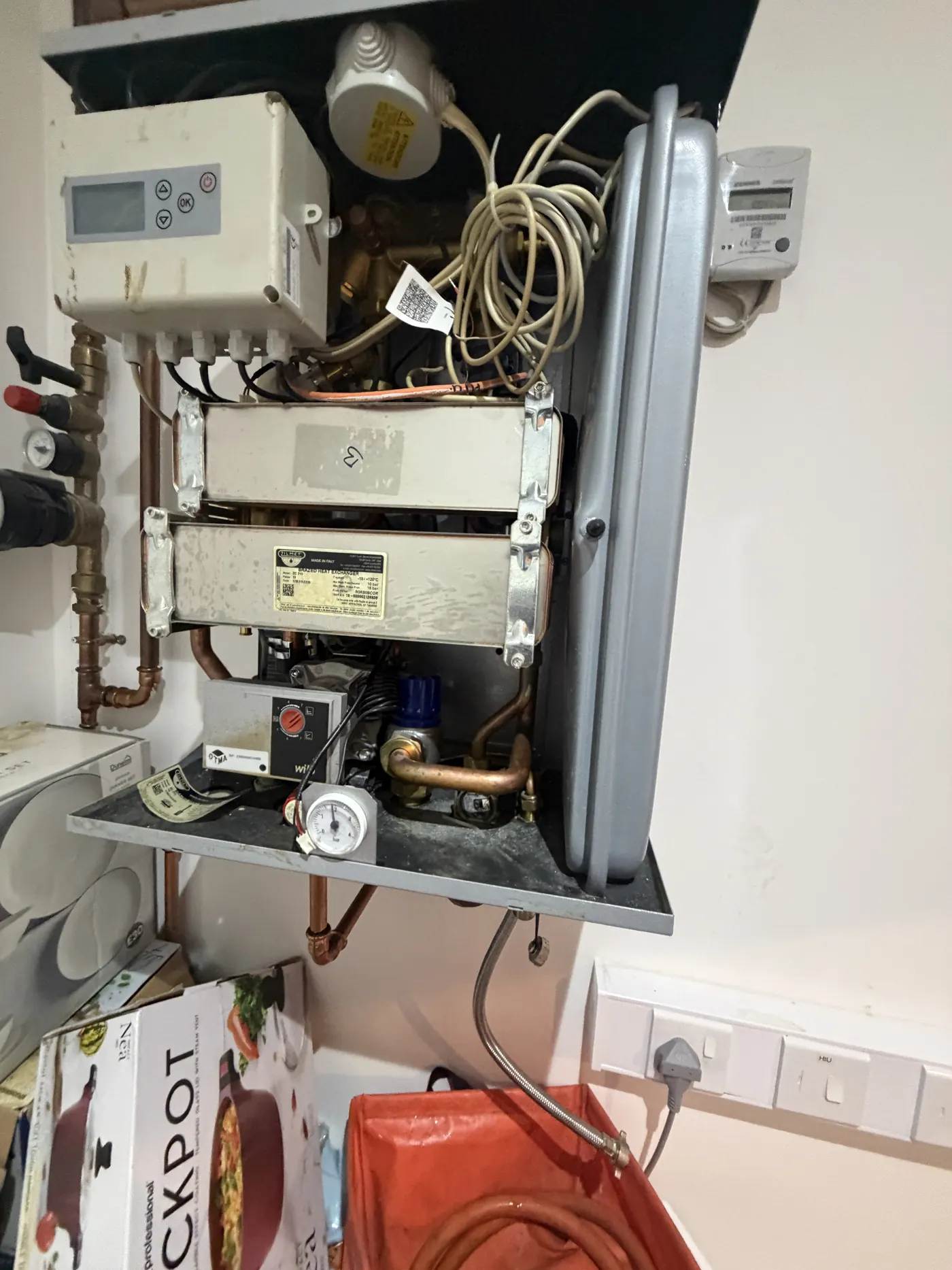 Heat interface unit with the cover removed in a Birmingham city centre flat, showing the plate heat exchangers and pump