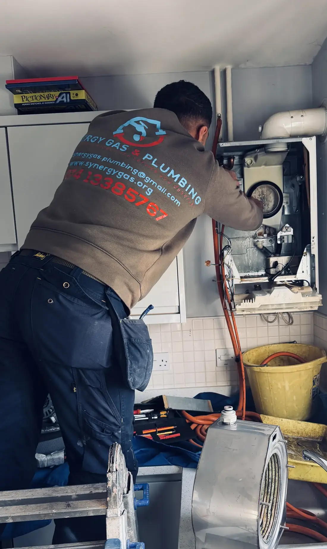 Engineer refitting the heat exchanger and fan assembly into the Glow-worm boiler