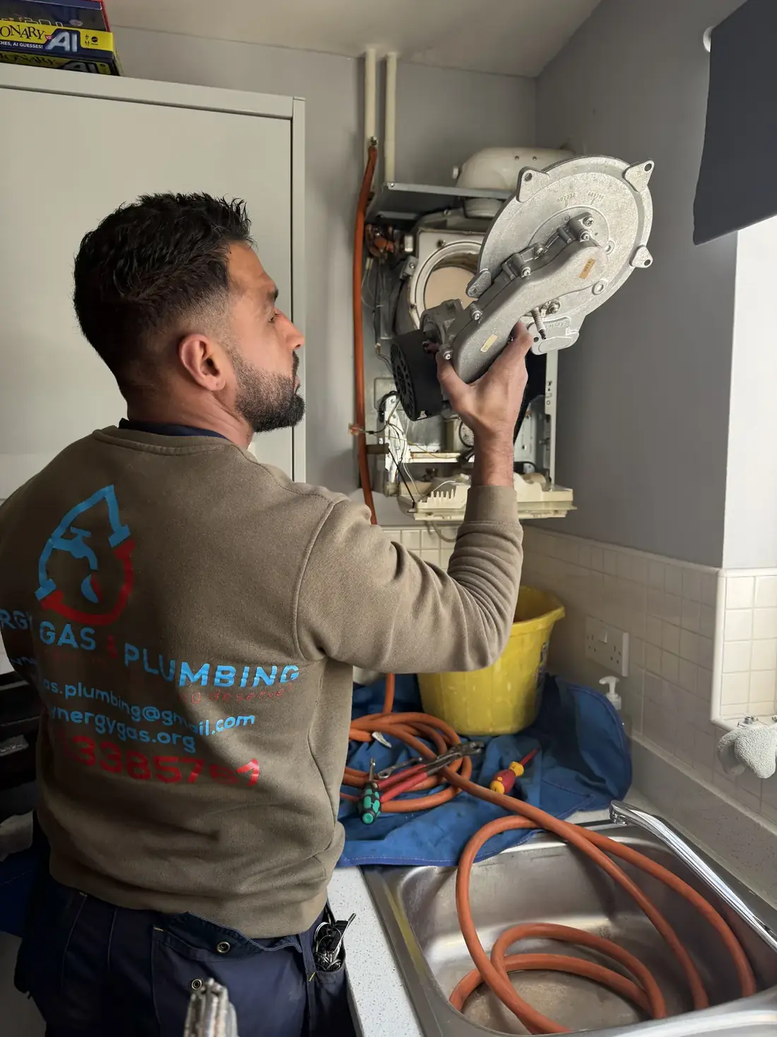 Engineer lifting the fan and heat exchanger assembly out of the Glow-worm boiler