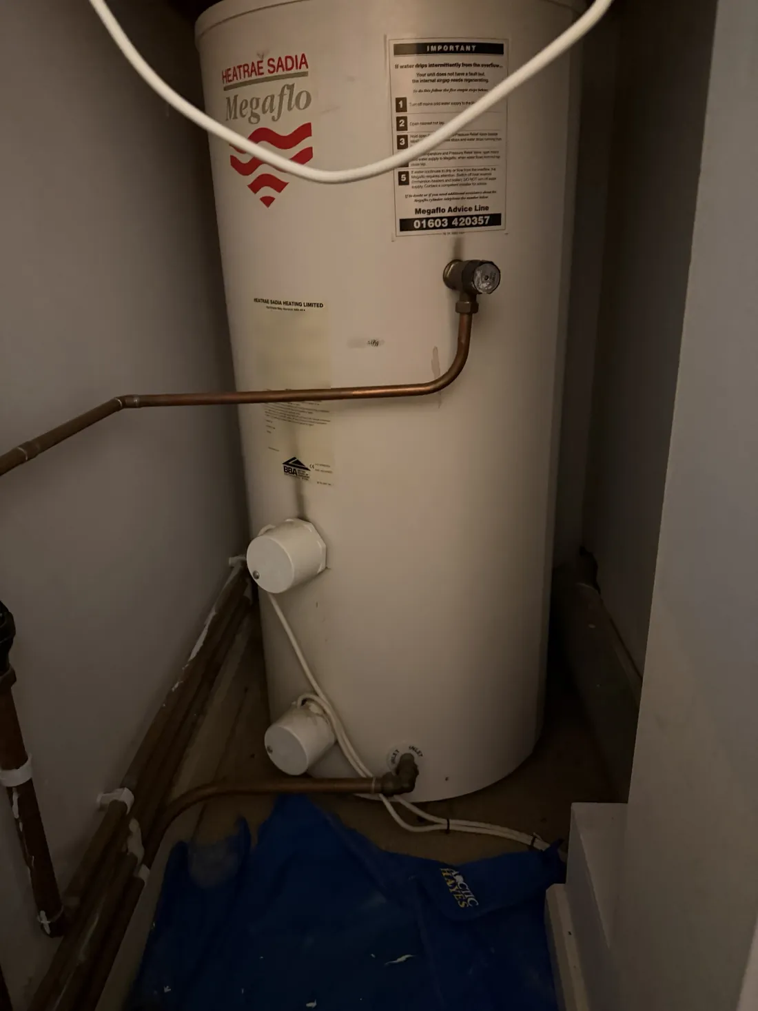 Heatrae Sadia Megaflo unvented hot water cylinder in a cupboard in a Birmingham city centre flat, with two immersion heater housings on the front