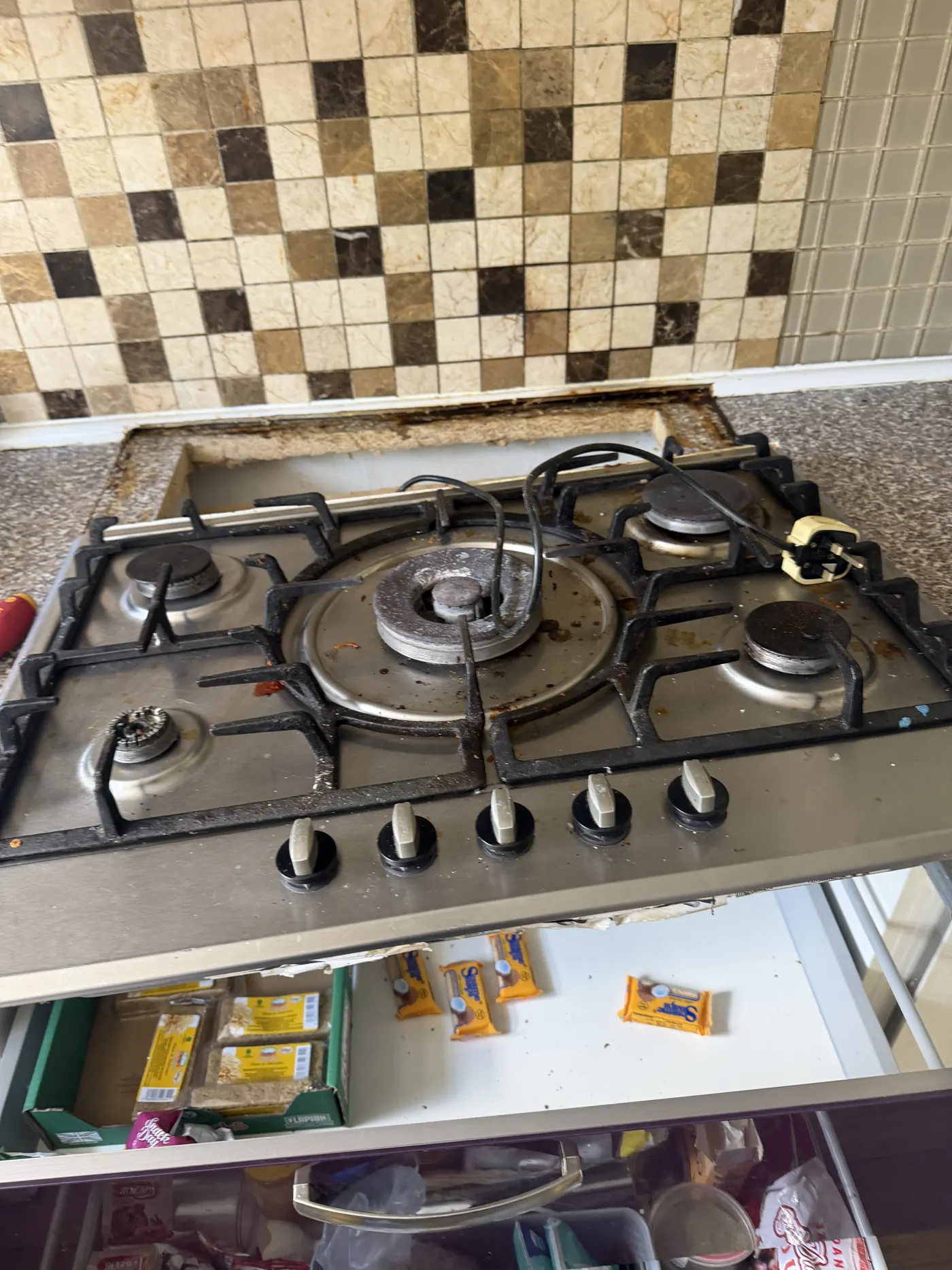 Worn and soiled five-burner gas hob in an Edgbaston rental kitchen before replacement