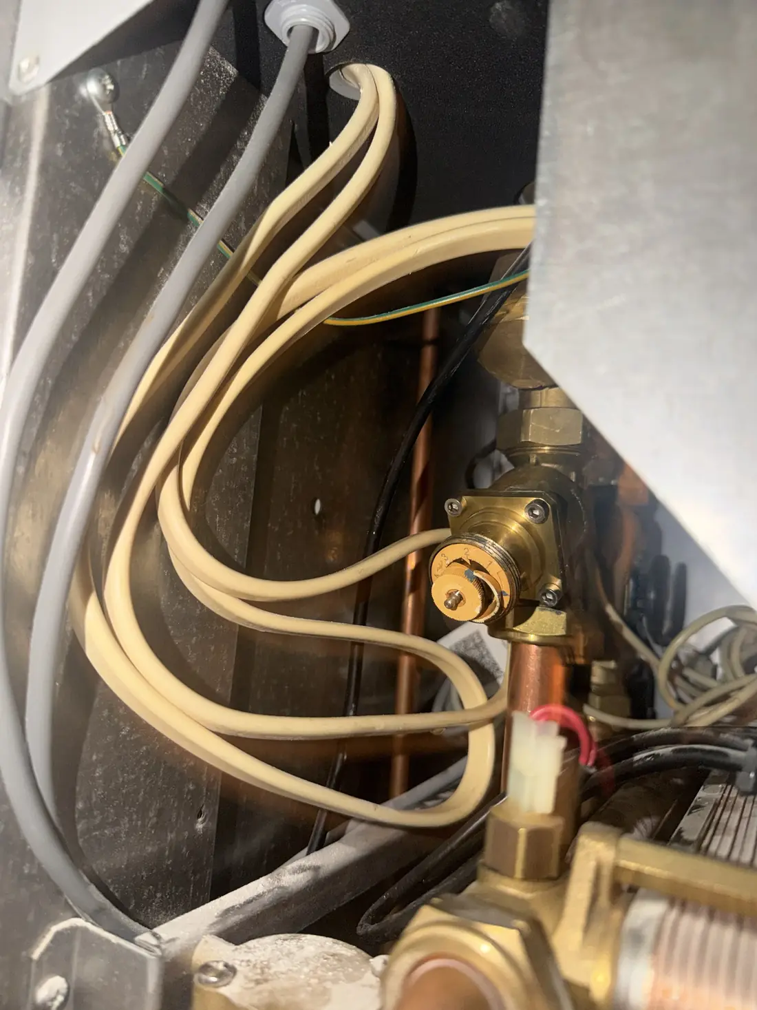 Close-up of the brass pressure independent control valve inside the heat interface unit with its numbered setting dial