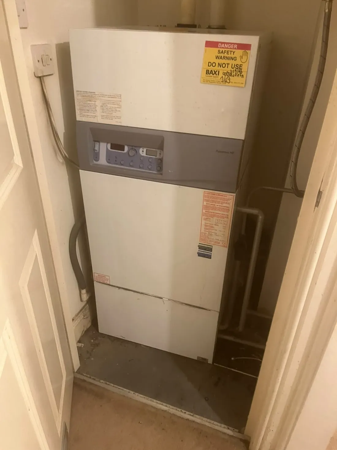 Potterton Powermax HE floor-standing boiler in an Erdington cupboard with a Danger Do Not Use warning label on the front