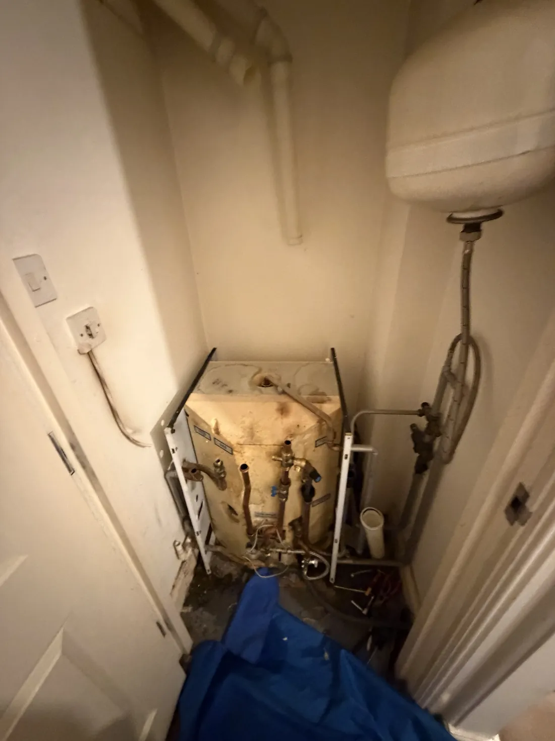 The hot water store section of the old Potterton Powermax part way through removal in a hallway cupboard