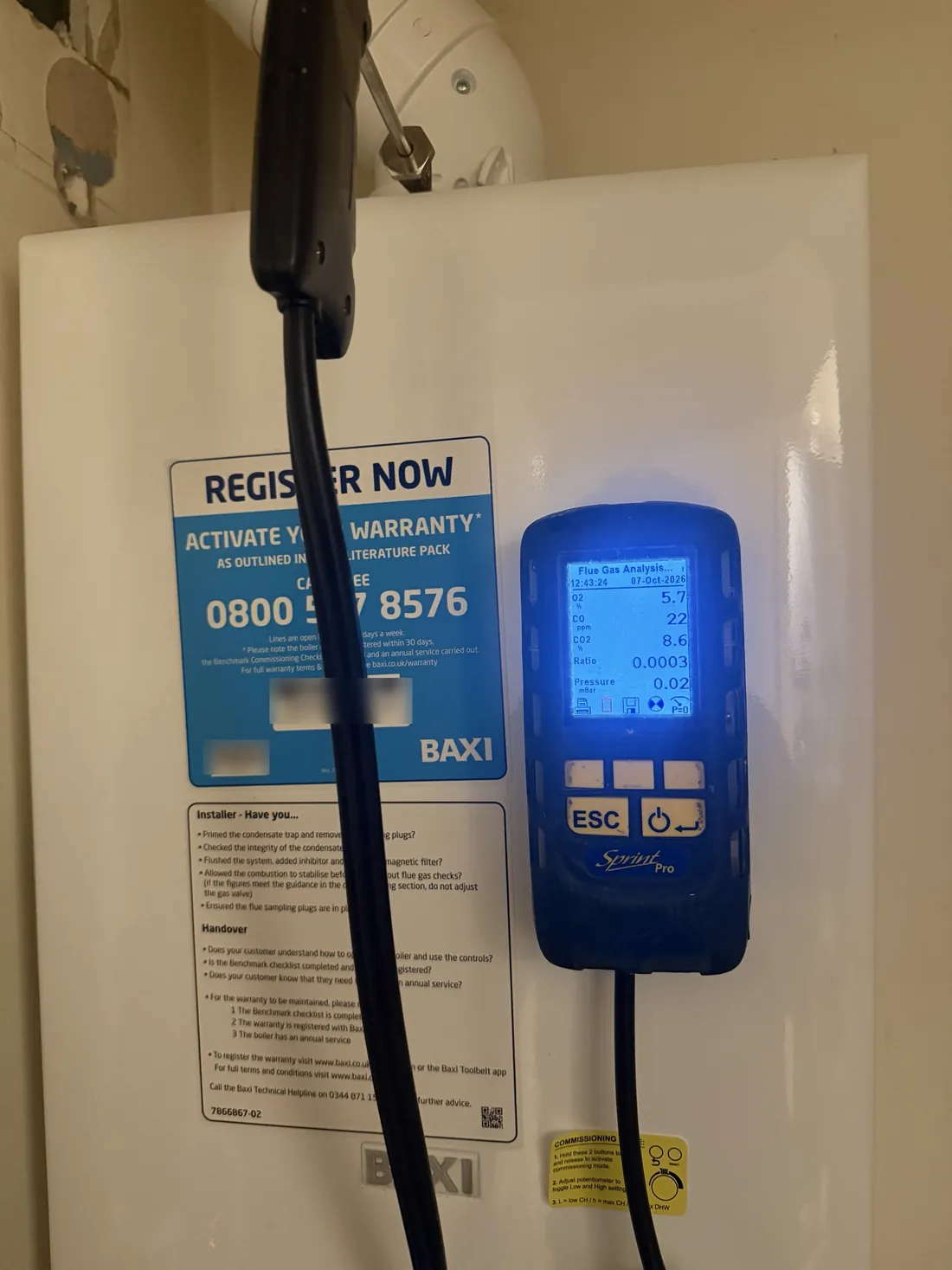 Flue gas analyser reading on the front of the new Baxi combi boiler showing carbon monoxide at 22 ppm and a ratio of 0.0003