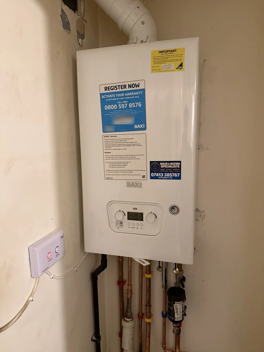 Finished Baxi 400 combi boiler installation in a hallway cupboard in Erdington, with copper pipework and a Sentinel filter below