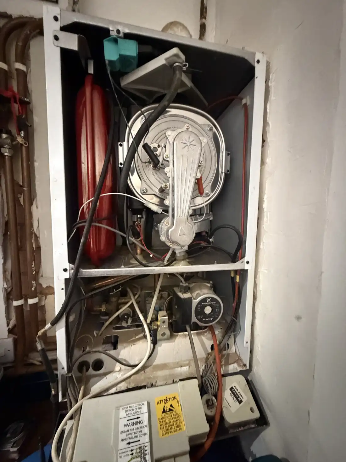 Potterton Gold combi boiler with the front case off, showing the expansion vessel, burner and fan, and the control box below