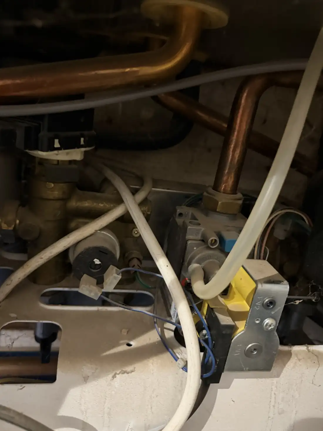 The pipework, valves and gas valve underneath a Potterton Gold combi boiler
