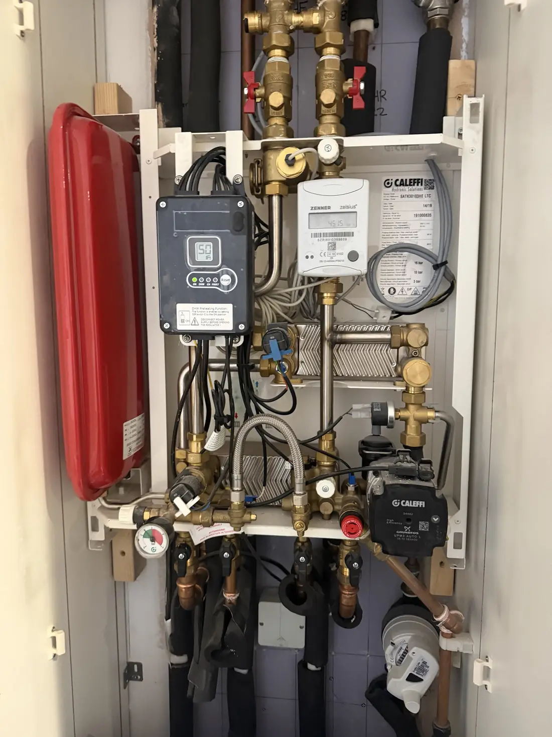 Caleffi SATK heat interface unit in a Jewellery Quarter apartment cupboard with the front cover removed for servicing