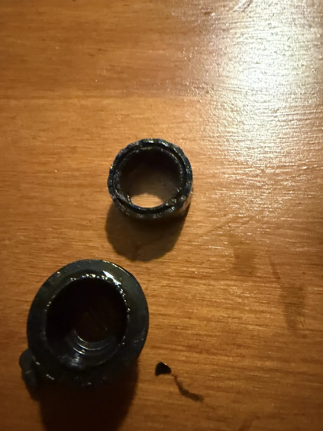 Old black rubber parts from a leaking boiler flow adapter on a wooden surface