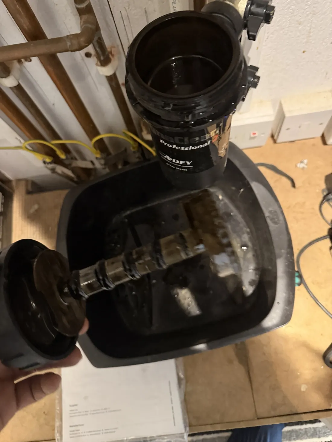 Adey MagnaClean Professional 2 magnetic filter opened, with black magnetite sludge on the magnet core