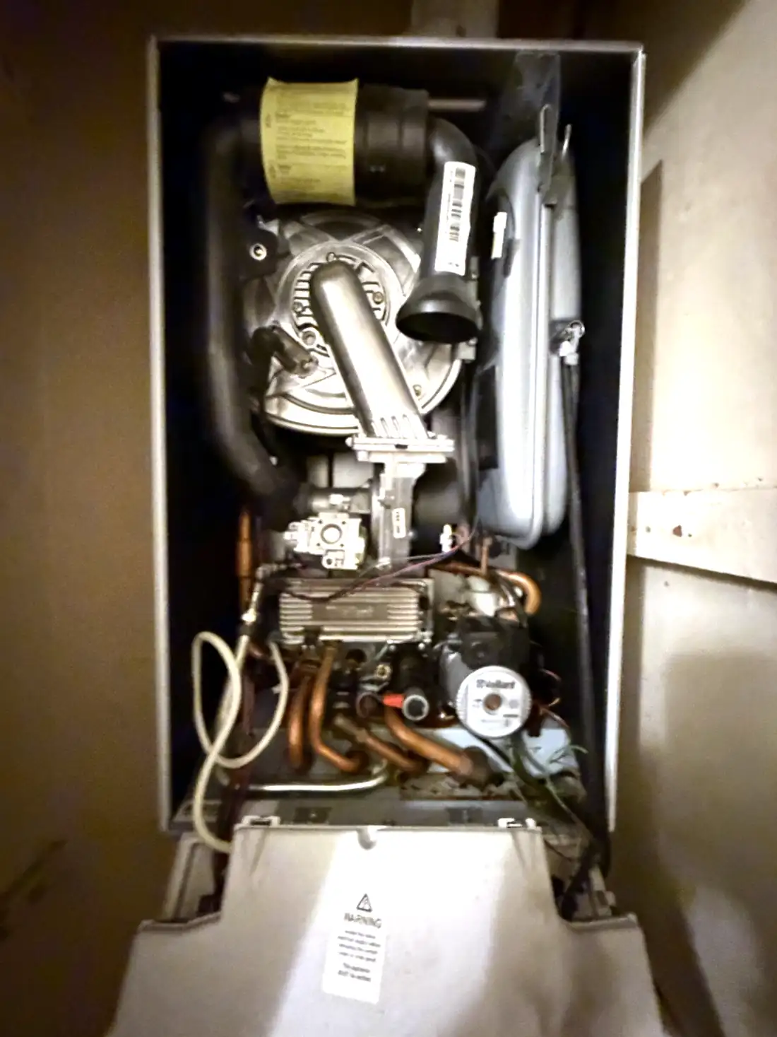 Vaillant ecoTEC combi boiler with the front case off, showing the original pump at the bottom right