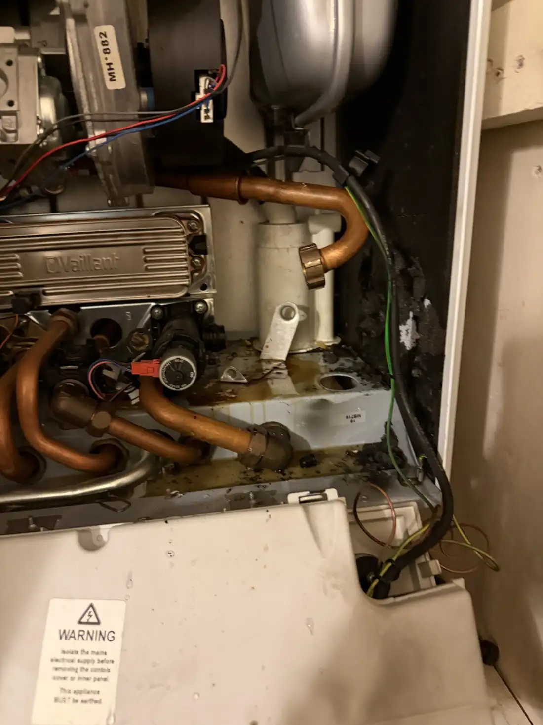 Inside a Vaillant ecoTEC with the old pump removed, showing water marks and corrosion on the base of the boiler