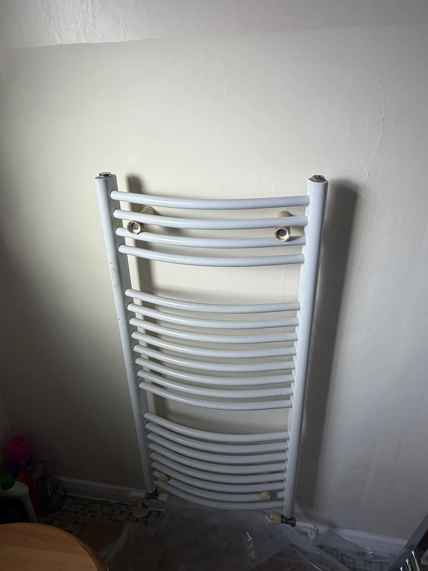 The old white curved towel radiator on the bathroom wall in Rowley Regis before replacement