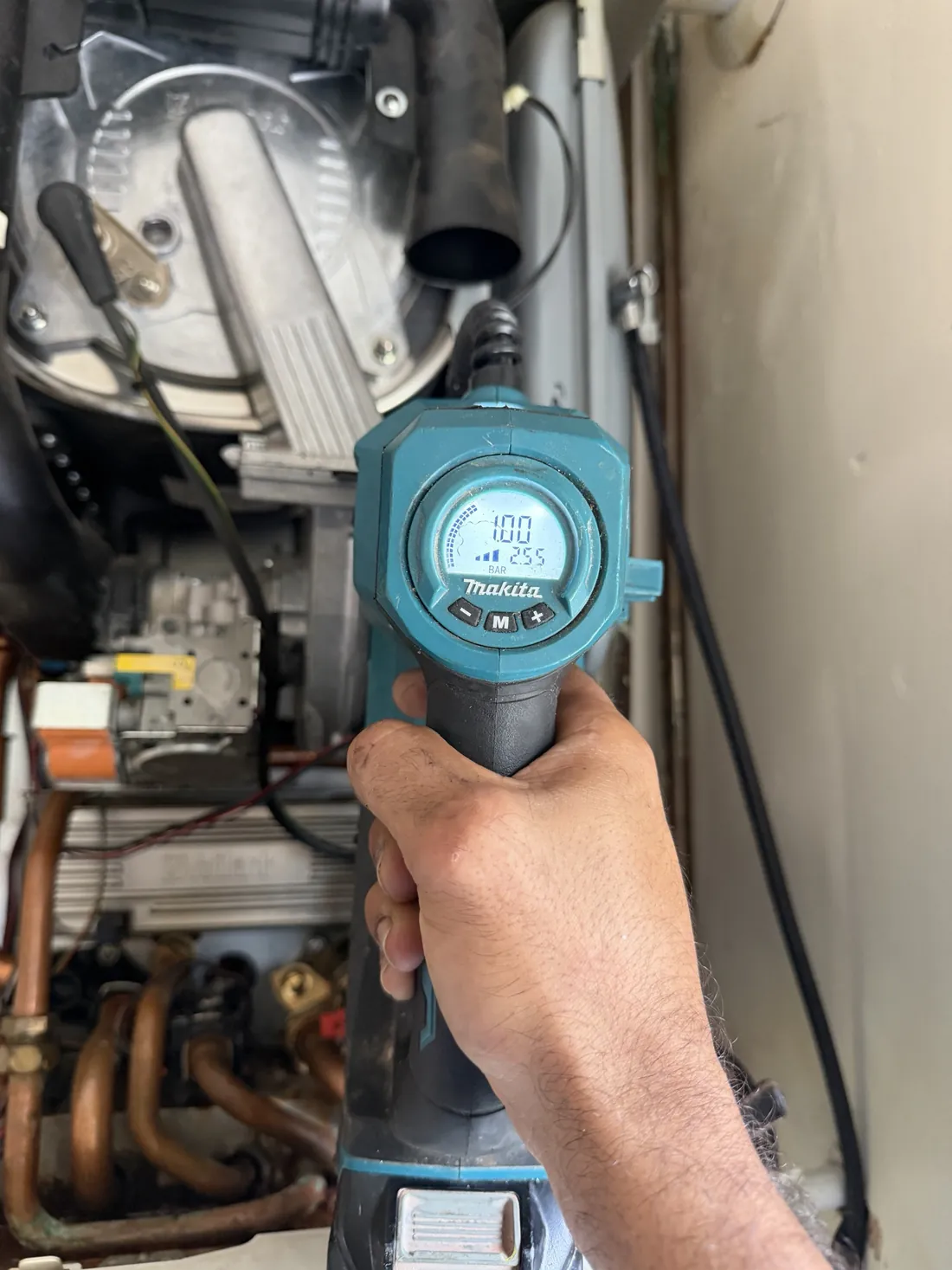 Engineer checking the expansion vessel charge on a Vaillant ecoTEC pro 28 with a pump gauge reading 1.00 bar