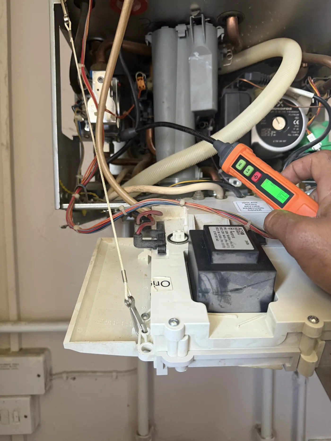 Engineer using a gas detector to check around the new gas valve and connections inside the boiler
