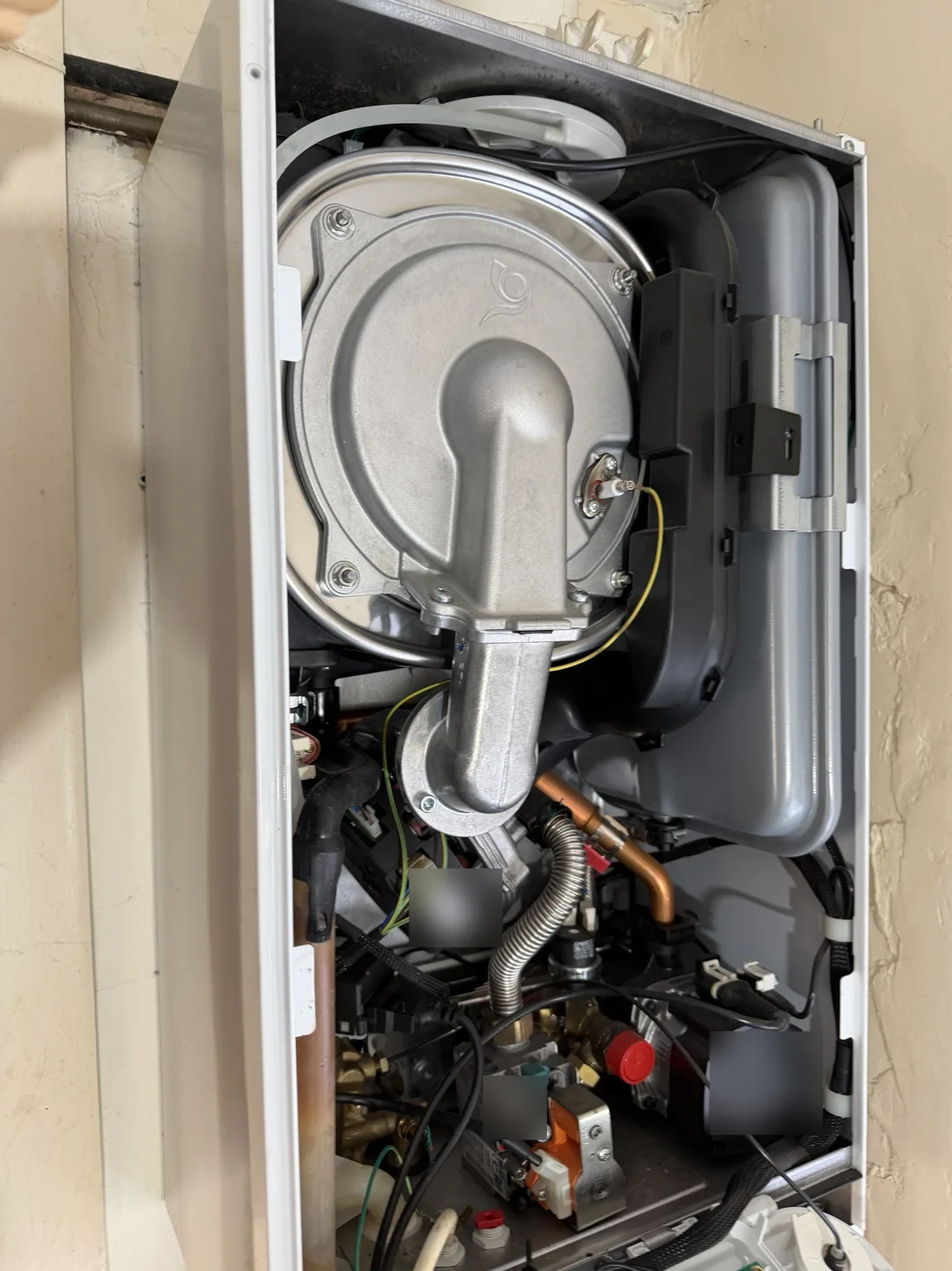Potterton Assure boiler with the front case off, showing the burner and fan, the expansion vessel, the gas valve and the pump