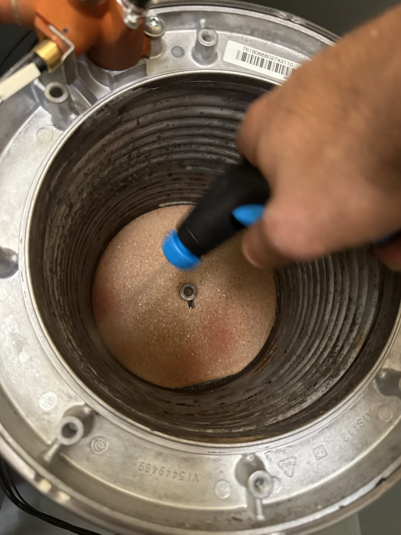 Engineer cleaning the inside of the Viessmann stainless steel heat exchanger with a brush