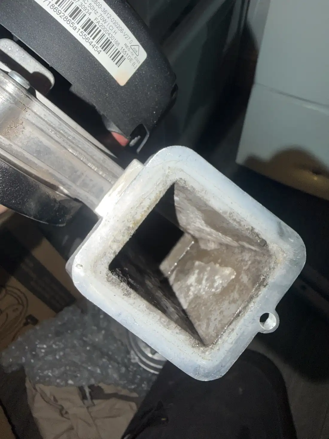 The outlet of the old boiler fan, with dust and debris built up inside