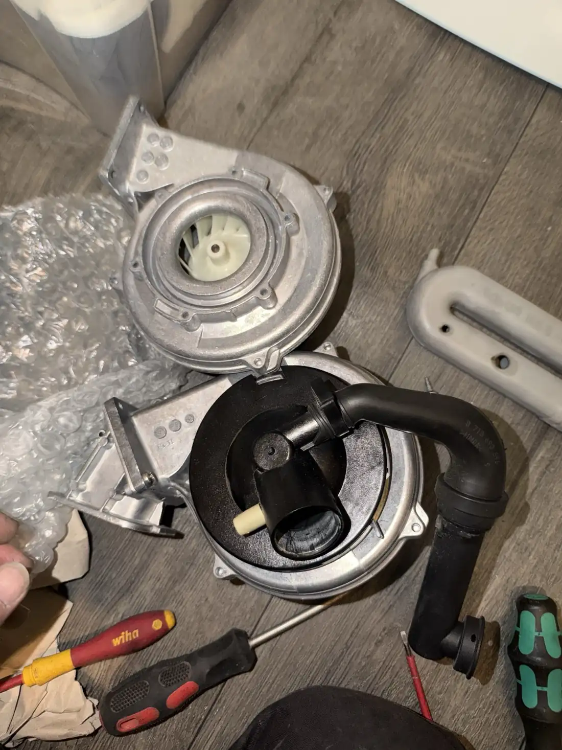 The old Worcester boiler fan beside the new replacement fan on the floor