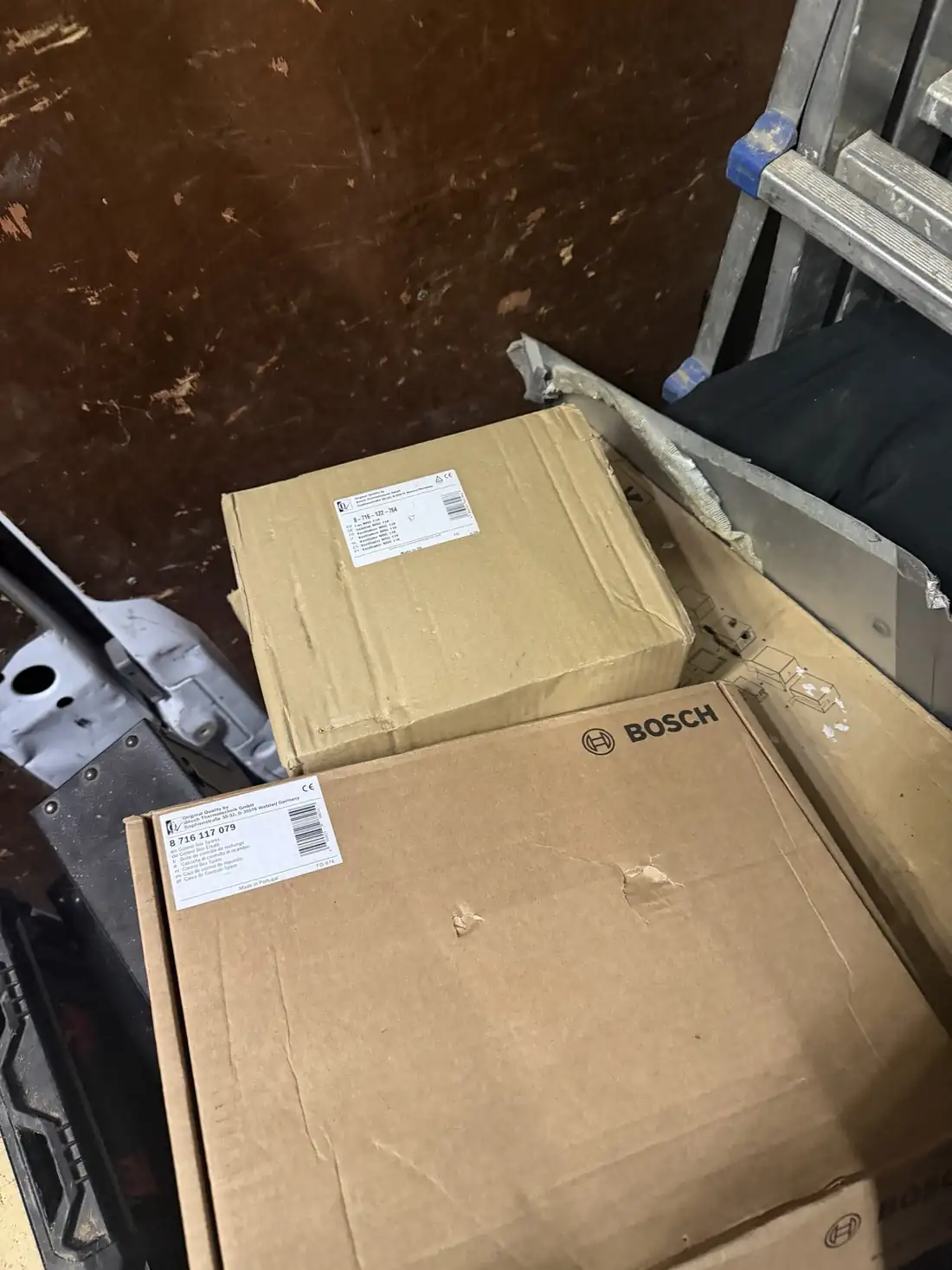 Two Bosch Thermotechnik part boxes, a replacement fan and a control box spare, in the back of our van
