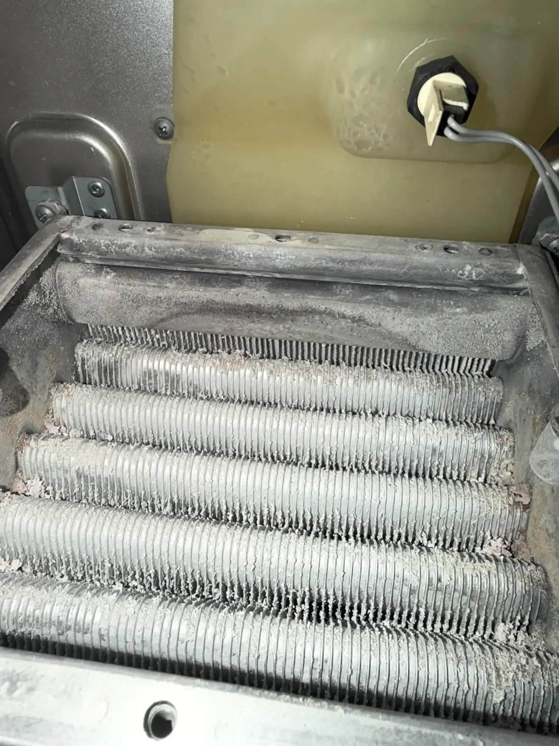 Vokera heat exchanger before cleaning, with the fins fouled with debris and deposits