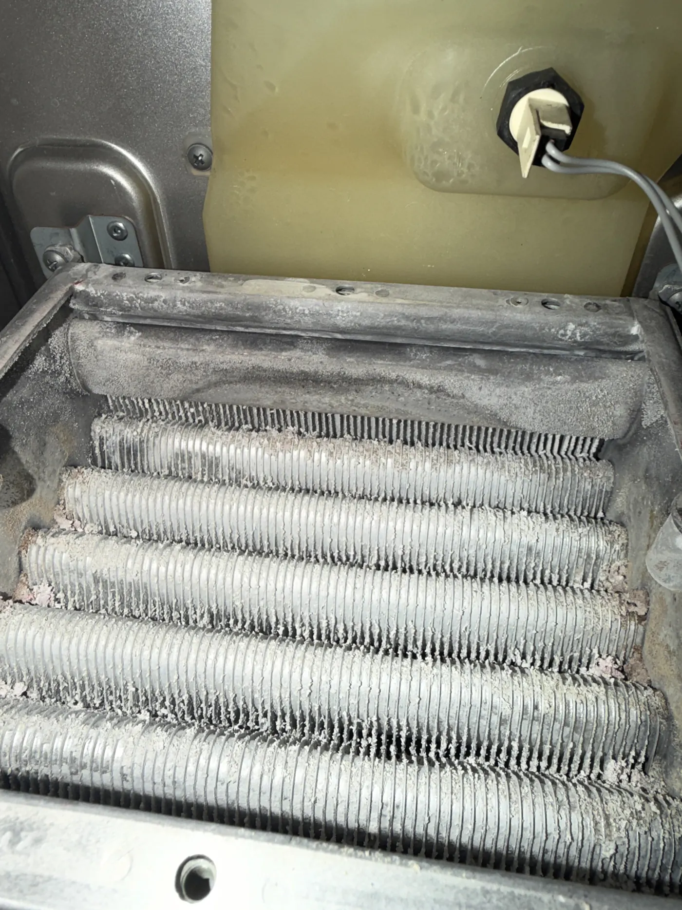 Vokera heat exchanger before cleaning, with the fins fouled with debris and deposits