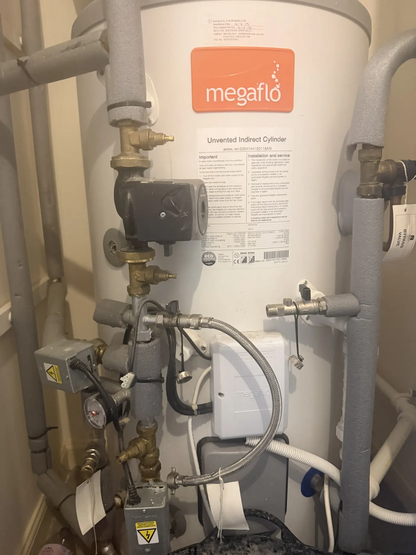 The burnt-out system pump on the pipework beside a Megaflo unvented cylinder in the Walsall rental property