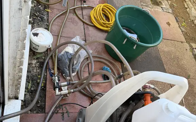 Power flushing machine and hoses set up outside a Wolverhampton rental